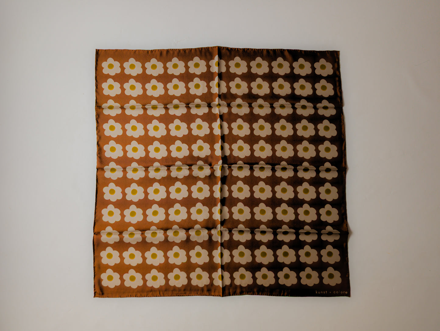 Floral patterned silk scarf on a plain background