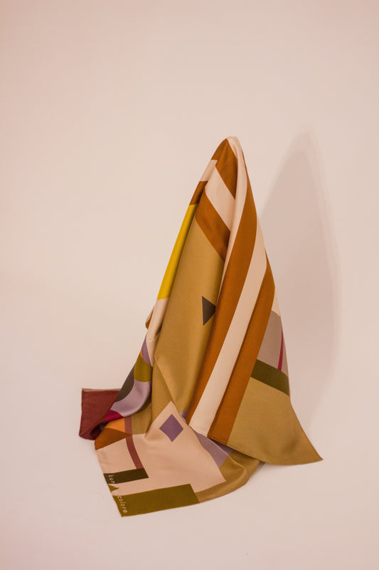 The 'Mustard Metropolis' scarf by Kunst & Colore hanging artfully, showing the fullness of the print. 
